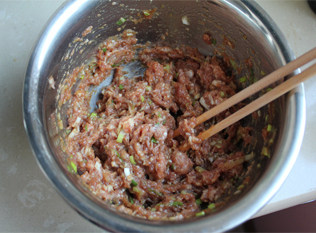 5、香得让人止不住口——猪肉大葱馅饼,用力顺时针搅拌,把油都打入肉馅里,把肉馅搅拌上劲。