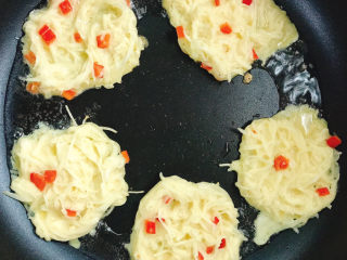 9、土豆鸡蛋饼,不粘锅中放入花生油，放入土豆丝，用筷子摊成饼。