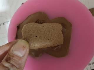 13、大黄蜂慕斯蛋糕,将做好的慕斯糊倒入大黄蜂模具中！倒一半时加一片饼干片！快倒满时再加一片饼干片！轻磕几下，将慕斯糊震平！将慕斯放冰箱冷冻室！冷冻过夜（一定要冷冻，否则不能脱模！冻得时间一定要足够！我冻了一天一夜）