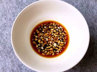 11、福州炒线面,取一小碗,放入一半的蒜末,放入20g生抽,10g料酒,10g蚝油,5g白糖,5g鸡精,搅拌至融化