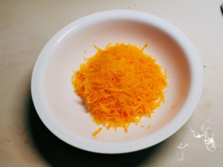 3、胡萝卜鸡蛋饼,胡萝卜用擦丝器擦成细丝。