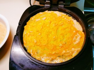 11、胡萝卜鸡蛋饼,均匀摊开,选择适合的功能键,开始煎制。