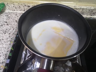 8、宝宝无糖奶酪棒,牛奶煮开了,转小火。这时就放芝士片,继续搅拌