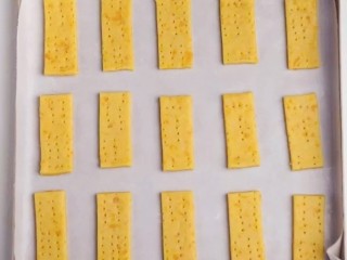 21、咸蛋黄饼干,摆到铺好硅油纸的烤箱上,放入预热好的烤箱,180度烘烤10分钟,取出翻面再烘烤10分钟即可