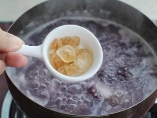 6、紫薯小米粥,待山药和紫薯软熟、粥呈稍微黏稠状态加入冰糖，搅拌至冰糖融化。