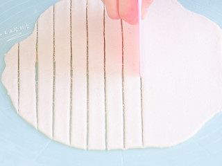 4、豆腐手指脆条,拿出来已经不粘手了，直接不撒粉擀，拿起来也不粘垫子。将面团擀成面片，切成条状。