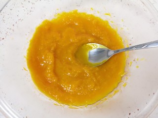 3、南瓜糯米饼,蒸熟的南瓜从蒸锅里取出,放进大一点的盆里,用勺子压成南瓜泥。