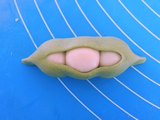 14、????豌豆荚小馒头????,翻面过来再整理一下形状,两头捏成小尖尖。