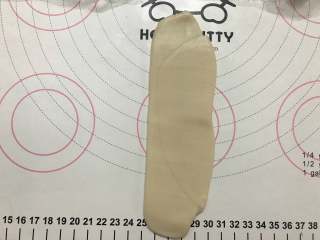 7、红豆酥饼,把做好的面团进行第二次擀卷，先把面团按扁，擀成长舌状。