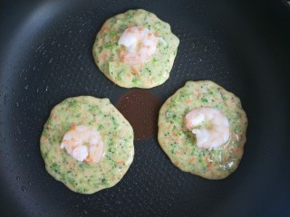 14、西兰花虾饼,然后把煮熟的虾仁放在饼的正中心。用力稍往下压一下。