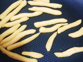 10、宝宝零食：简易版虾条,平底锅小火烧热后 均匀的码上虾条 （因为面团中加过了油 所以锅内不需要刷油哦 ）
