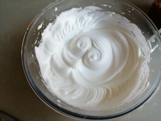 8、4寸可可蛋糕,共分三次加入糖,用电动打蛋器打发至偏干性发泡的蛋白霜