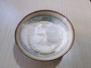 4、红丝绒玛德琳蛋糕,加入纯牛奶，充分搅拌融合！筛入低筋面粉与泡打粉。