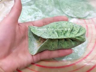 9、菠菜柳叶包子,取一张包子皮码上适量的馅料，用拇指和食指捏一个褶儿，然后顺着食指方向捏褶，捏完稍整形整成弯弯的柳叶形状