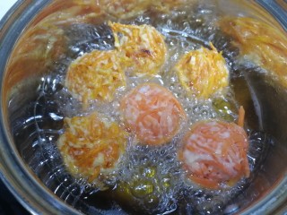 13、炸胡萝卜丸子,炸至一面定型金黄后，翻面。