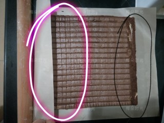 21、可可旋风蛋糕卷,晾网会在蛋糕表面留下一些痕迹，没关系。这个痕迹反而可以帮助更好的卷起来。蛋糕放在新的一张油纸或者油布上。切掉蛋糕的四边，然后在要卷的两端都斜着切掉一点边。黑色画线区域。在白色画线区域，切几道痕迹，但是不要切断。然后借助一根擀面杖卷起来。也可以抹上奶油或者果酱。我为了花纹好看什么也没有抹。