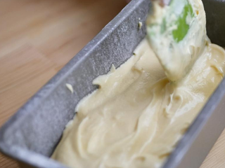 6、柠檬糖霜磅蛋糕,将麵粉分三次筛入，用刮勺用翻拌的方式直到看不见乾粉；将拌好的麵糊倒入烤模内，敲几下以排出空气