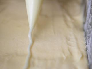 7、柠檬糖霜磅蛋糕,在麵糊表面的中间，挤一条、或切一条细长的奶油，可帮助烘烤时裂纹比较漂亮