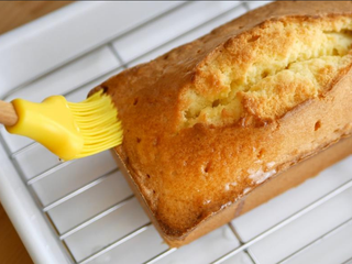 10、柠檬糖霜磅蛋糕,出炉后的磅蛋糕先放10-15分鐘，时间到脱模，用竹叉在上面戳几个洞，趁蛋糕还热涂上柠檬糖浆，放至完全凉透