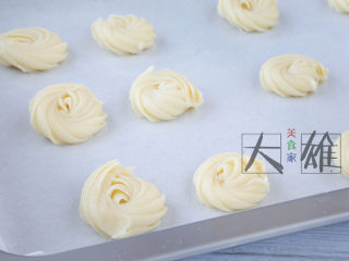 2、最简单的烘焙:黄油曲奇,铺一张烤纸，将饼干液挤到烤盘上