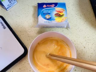 3、献礼祖国70周年华诞-芝士火腿鸡蛋手抓饼,加入牛奶的蛋液搅拌均匀。