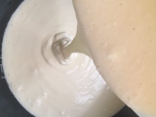 8、电饭煲蒸蛋糕,预热几分钟后缓缓倒入蛋糕糊（为了避免有大量气泡 需要震几下）面糊一定是浓稠而细腻 翻拌后变稀就是消泡 很难成功了）
