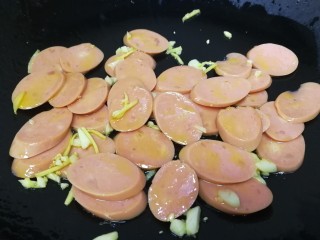 9、荷兰豆炒香肠,放入香肠，文火把香肠煎一下。