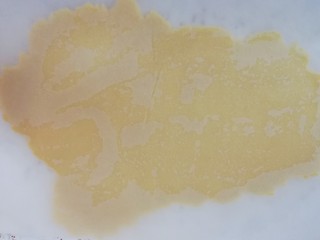 6、圣诞树饼干,台面上铺油纸，放上变硬的面团压扁，上面再盖上一层油纸，擀至3mm厚度即可。