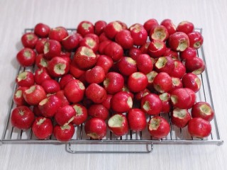 5、时令养生～山楂罐头,之后用水果刀将根部挖干净！依次挖好，放烤网上淋干水分，如图。