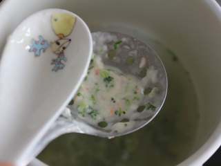 7、鲜虾蔬菜粒粒面（适合11个月龄以上的宝宝）,将面糊倒到漏勺上，并用勺子转动挤压，使面糊自动滴落到锅里