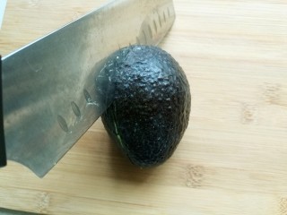 2、辅食计划十牛油果香蕉卷,牛油果沿着果核中间切一圈。