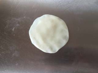 13、莲蓉蜜豆冰皮月饼,取一个冰皮将其压扁，边缘稍微薄一些。