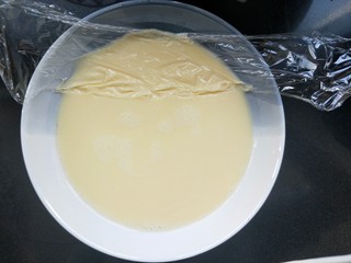 7、蔓越莓牛奶蒸蛋,表面仍有一些泡沫,可以用小勺撇掉。我是用一段保鲜膜贴在表面拉一下,就可以带走那些浮沫。