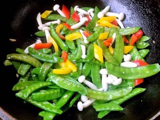 7、缤纷荷兰豆,放入海鲜菇、黄椒、红椒快速翻炒