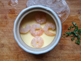 10、虾仁蒸蛋羹,水开以后蒸八分钟,取出,注意不要烫到手啊。将剩余虾仁摆在鸡蛋羹上面。