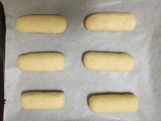 9、#宝宝零食#自创奶酪夹心燕麦棒,之后放在铺好油纸的烤盘上，放入烤箱，开启发酵模式15分钟