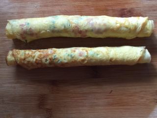 9、火腿蒜香鸡蛋卷,趁有温度时轻轻卷成卷，尽量卷紧一点哦，不然易松散开来