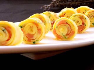 11、火腿蒜香鸡蛋卷,然后摆入餐盘中即可（漂亮或有趣的造型也能促使宝宝的食欲哦）。喜欢吃蕃茄酱、沙拉酱的也可搭配食用哦