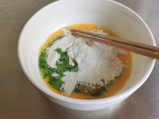 4、菠菜鸡蛋面,然后倒入菠菜汁，菠菜汁要一点一点的倒，边倒边搅拌面粉。