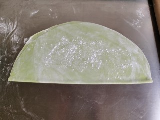9、菠菜鸡蛋面,擀好后的面皮撒上一层面粉防粘，然后对折起来。