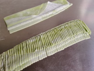 12、菠菜鸡蛋面,把折好的面皮切成粗细均匀的面条。面条的宽窄看自己喜欢，可以切细一点，也可以切成宽面条。