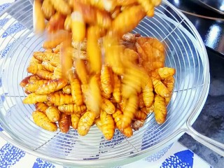 4、韭香蚕蛹,来到漏勺,沥一下水。