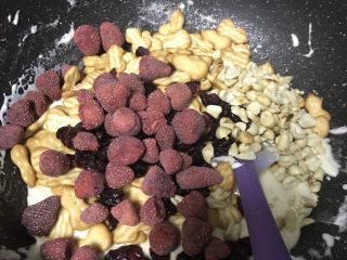 5、超好吃零食雪花酥,再继续加入熟花生粒，草莓干，蔓越莓，饼干混合物。