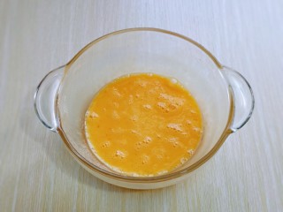 2、快手早餐～蔬菜鸡蛋饼,首先将鸡蛋磕大口器具中，用手动打蛋器打散。
