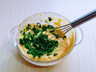 8、快手早餐～蔬菜鸡蛋饼,切好的芹菜叶子加入面糊中，搅拌均匀。