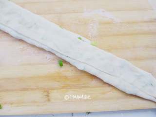 7、香葱味手撕饼,像折扇子一样叠在一起，折叠好从面条的一头往里卷.一边抻长一边卷，拽的越长，层次越多