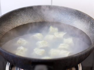 11、荠菜鸡肉馄饨,锅里放适量的水,把水煮开。放入小云吞,用小勺轻轻推动小云吞的底部,避免粘锅。当水开了后,倒入少许的凉水,盖上锅盖,这样反复二次,小云吞漂起来就熟了。