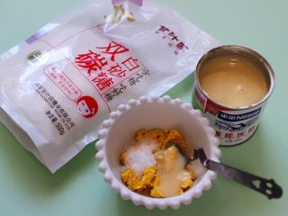 5、星空水晶奶黄汤圆,现在来制作奶黄馅:煮熟的蛋黄放入碗里用勺子压成泥状,放入甘汁园双碳白砂糖,再加入炼乳