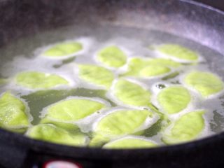 14、荠菜饺子#春意绿#,锅中加入适量清水烧开、把包好的饺子放入锅中、大火烧开、点少许清水、反复3次、看见饺子都漂浮于表面即可关火