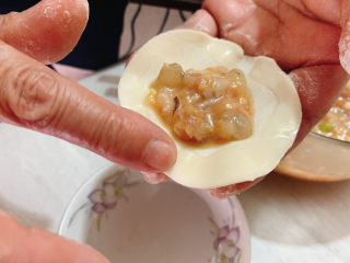 13、三鲜蒸饺,用手指沾适量水抹在饺子皮边沿，这样包起来皮黏的更紧。
